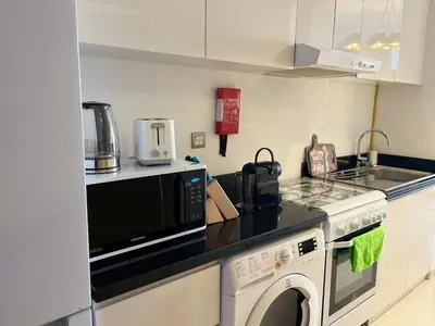 a kitchen with a microwave oven and a washer at Top Floor Luxurious Apt in JVC, Near Marina in Dubai