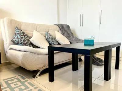 a living room with a couch and a table at Top Floor Luxurious Apt in JVC, Near Marina in Dubai