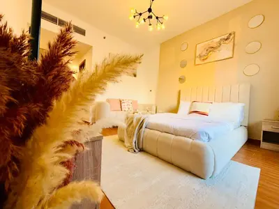 a bedroom with a bed and a couch in it at Aesthetically Designed Lavish Apt, Near Marina in Dubai
