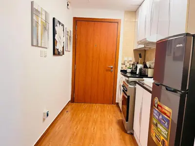 a kitchen with a wooden door and a wooden floor at Aesthetically Designed Lavish Apt, Near Marina in Dubai