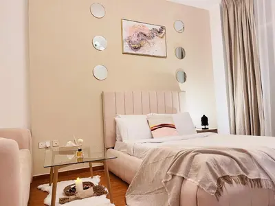 a bedroom with a bed and a couch and clocks on the wall at Aesthetically Designed Lavish Apt, Near Marina in Dubai