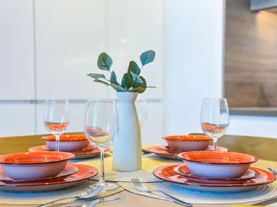 a table with plates and wine glasses and a vase at Super Luxury Flat Desing with Sea, Marina and Pool View in Dubai
