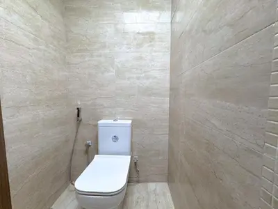 a bathroom with a toilet and a tile wall at Barsha Star Residence 2-HomeStay in Dubai