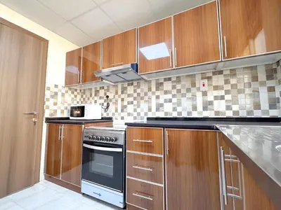 a kitchen with wooden cabinets and a stove at Barsha Star Residence 2-HomeStay in Dubai