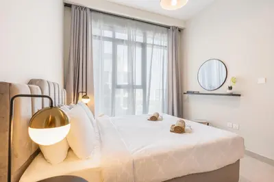 a bedroom with a bed and a large window at Bright & Modern Home with Burj Khalifa Views in Dubai
