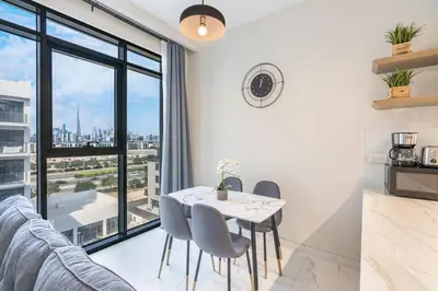 a dining room with a table and chairs and a large window at Bright & Modern Home with Burj Khalifa Views in Dubai
