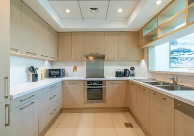 a kitchen with wooden cabinets and a sink at Luxurious 2-bedroom Apartment in Downtown with Burj Khalifa View in Dubai
