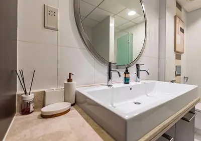 a bathroom with a white sink and a mirror at Luxurious 2-bedroom Apartment in Downtown with Burj Khalifa View in Dubai