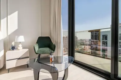 a glass table and a green chair in a room with a window at GuestReady - Elegant living in Downtown Dubai in Dubai
