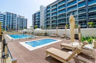 a swimming pool with lounge chairs and a building at GuestReady - Elegant living in Downtown Dubai in Dubai