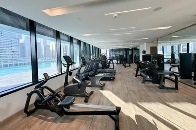 a gym with a row of treadmills and exercise bikes at Opulent Lifestyle with Burj Khalifa and Canal View in Dubai