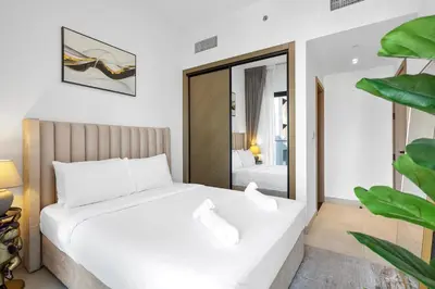 a bedroom with a white bed and a mirror at Opulent Lifestyle with Burj Khalifa and Canal View in Dubai