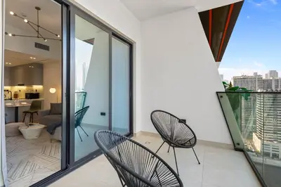 a balcony with two chairs and a living room at Opulent Lifestyle with Burj Khalifa and Canal View in Dubai