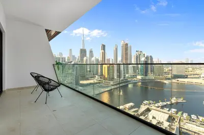 a chair on a balcony with a view of the city at Opulent Lifestyle with Burj Khalifa and Canal View in Dubai