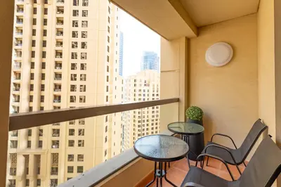 a balcony with tables and chairs and a view of buildings at Sadaf 5, Jumeirah Beach Residence, JBR - Mint Stay in Dubai