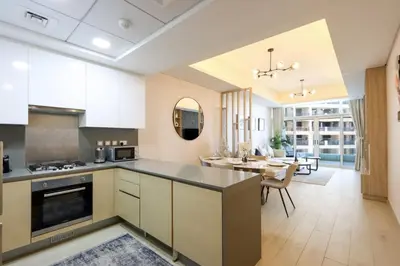 a kitchen with white cabinets and a dining room at Livbnb-Premium 1B with BurjAlArab Views in Mina in Dubai