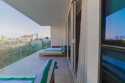 a balcony with two beds and a large window at Luxury 3BDR Apartment, Pool & Beach Access in Dubai