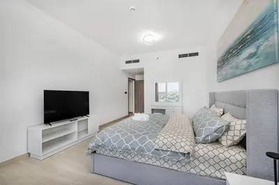 a bedroom with a bed and a flat screen tv at Luxurious 3Bedroom Apartment in Dubai