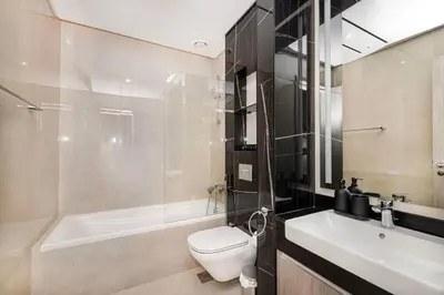 a bathroom with a toilet and a tub and a sink at Luxurious 3Bedroom Apartment in Dubai