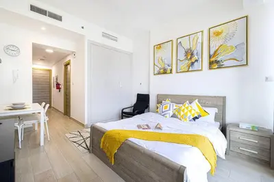 a bedroom with a bed and a desk and a table at Lovely Studio in Bloom Tower, 10 minutes to Marina in Dubai