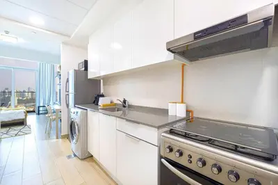 a kitchen with a stove and a refrigerator at Lovely Studio in Bloom Tower, 10 minutes to Marina in Dubai