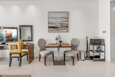 a dining room with a table and chairs and a microwave at Waves - Stylish Studio with Balcony in Dubai South in Dubai