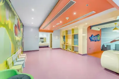 a room with chairs and a wall with a painting at Waves - Stylish Studio with Balcony in Dubai South in Dubai