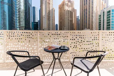 a table and two chairs on a balcony with buildings at La Vie, JBR - Your Perfect Holiday Gateway in Dubai