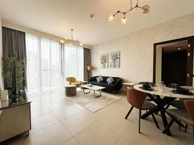 a living room with a couch and a table at Modern Elegance in Downtown 1BR with Luxe Decor by Petals Holiday Homes in Dubai