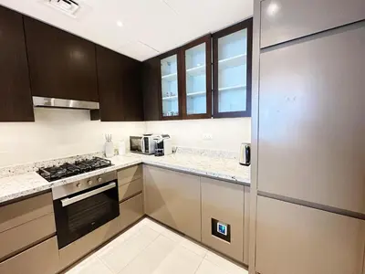 a kitchen with brown cabinets and a stove top oven at Modern Elegance in Downtown 1BR with Luxe Decor by Petals Holiday Homes in Dubai