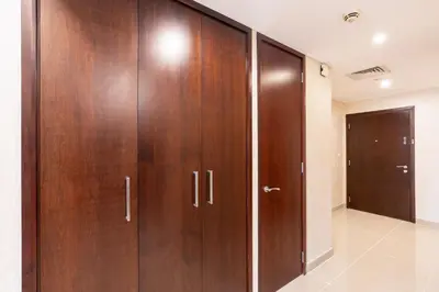 a row of wooden wardrobes in a room at Luxurious Apartment next to Burj Khalifa and Dubai Mall in Dubai