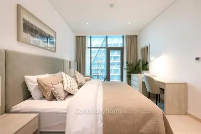 a bedroom with a bed and a desk and a table at 1 BR Rooftop Infinity Pool & Padel court in Dubai