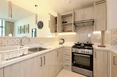 a kitchen with a sink and a stove top oven at 1 BR Rooftop Infinity Pool & Padel court in Dubai
