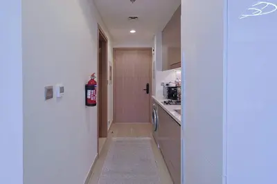 a small kitchen with a door and a hallway at Brand New Studio Near Downtown Dubai in Dubai