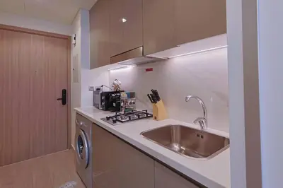 a kitchen with a stainless steel sink and a stove at Brand New Studio Near Downtown Dubai in Dubai