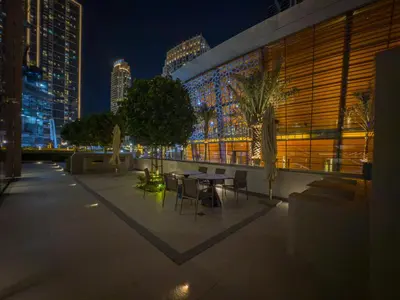 a patio with a table and chairs at night at Full Burj Khalifa & Fountain View All Rooms in Dubai