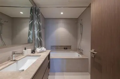 a bathroom with a tub and a large mirror at The View of a Lifetime - Luxury Living with Full Burj Khalifa & Fountain Show in Dubai