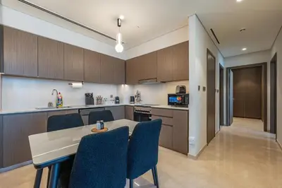 a kitchen with wooden cabinets and a table and chairs at The View of a Lifetime - Luxury Living with Full Burj Khalifa & Fountain Show in Dubai