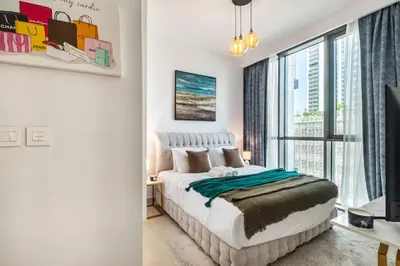 a bedroom with a bed and a large window at Classy Downtown Bliss with Dubai Mall Access in Dubai