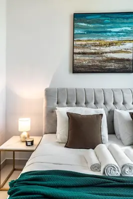 a bedroom with a bed with a painting on the wall at Classy Downtown Bliss with Dubai Mall Access in Dubai