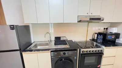 a kitchen with a sink and a stove and a dishwasher at Sleek 1BR in DSO, Dubai in Dubai