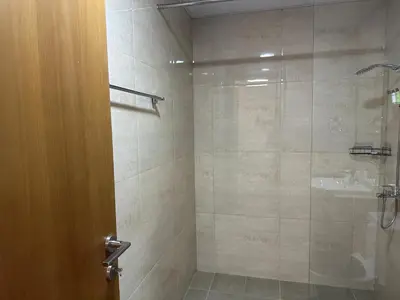 a bathroom with a shower with a glass door at Sleek 1BR in DSO, Dubai in Dubai