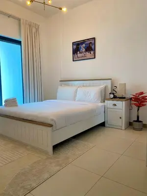 a bedroom with a large white bed and a window at Sleek 1BR in DSO, Dubai in Dubai