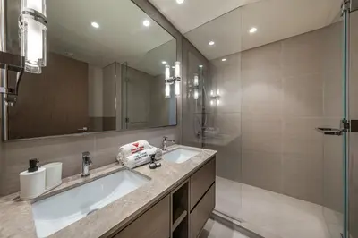a bathroom with a sink and a mirror and a shower at Skyline Majesty - Luxury Living with Full Burj Khalifa & Fountain Views in Dubai
