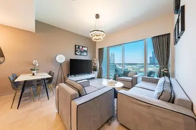 a living room with couches and a tv and a table at Skyline Majesty - Luxury Living with Full Burj Khalifa & Fountain Views in Dubai