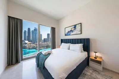 a bedroom with a large bed and a large window at Skyline Majesty - Luxury Living with Full Burj Khalifa & Fountain Views in Dubai