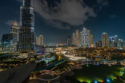 a city skyline at night with a tall skyscraper at Full Burj Khalifa & Fountain View Living & Bed in Dubai