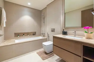 a bathroom with a tub and a toilet and a sink at Full Burj Khalifa & Fountain View Living & Bed in Dubai