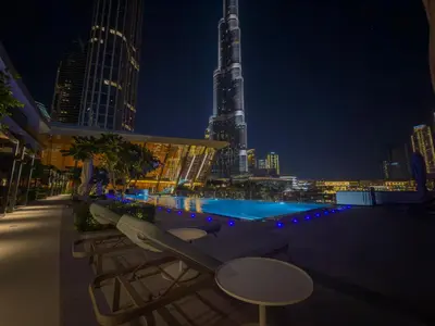 a rooftop pool with a view of a city at night at Full Burj Khalifa & Fountain View Living & Bed in Dubai