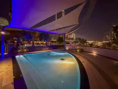 a swimming pool on top of a building at night at Full Burj Khalifa & Fountain View Living & Bed in Dubai